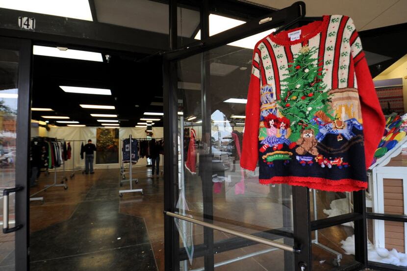 An ugly sweater hangs on the door giving customers a taste of one of hundreds of sweaters...
