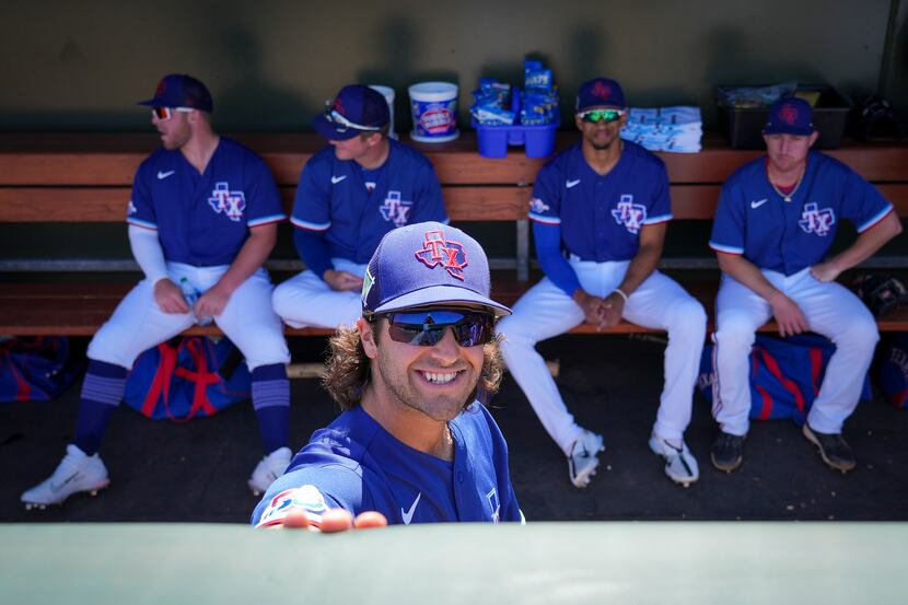 Texas Rangers infielder Josh Smith smiles in the dugout before a spring training game...