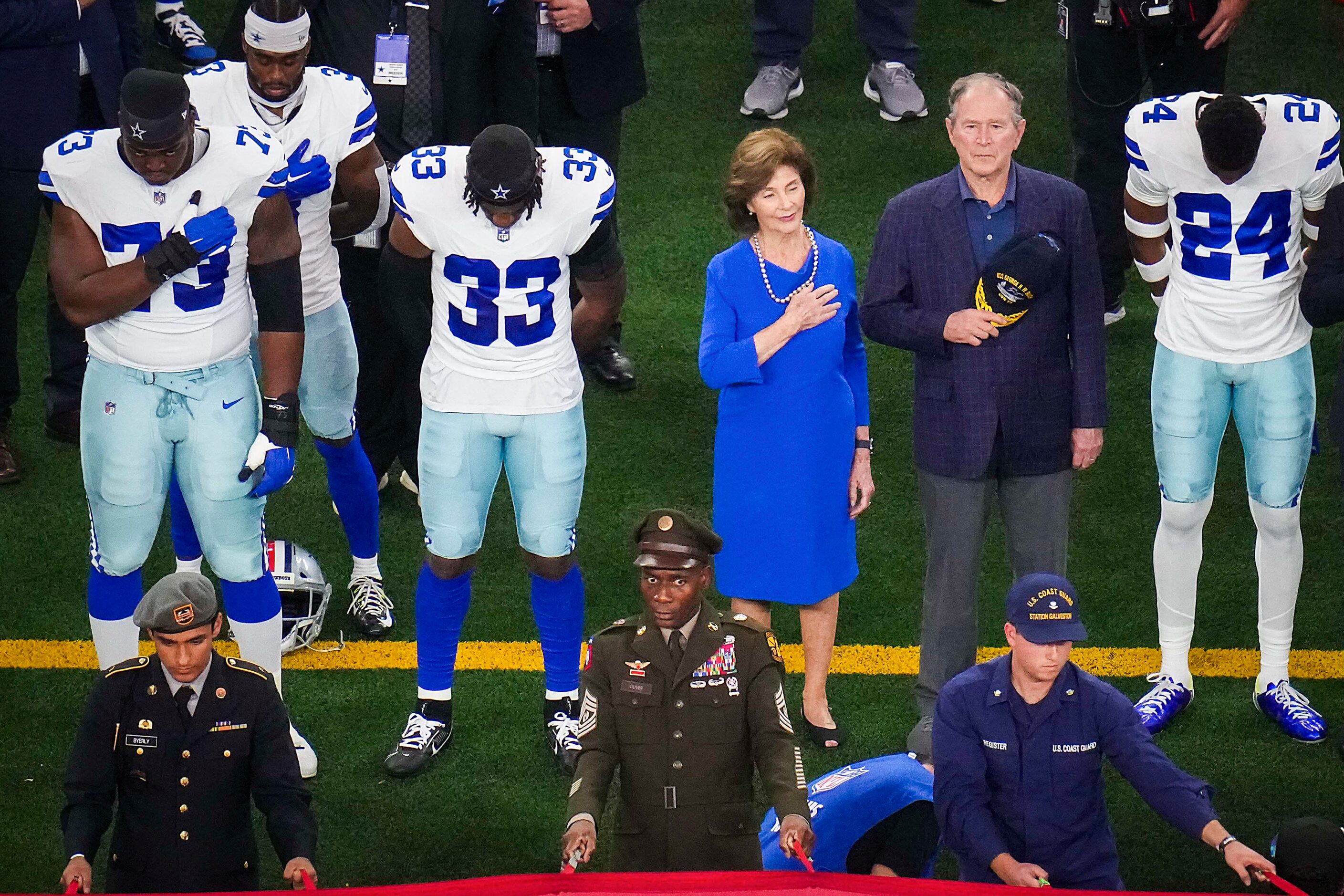 Former President George W. Bush and former first lady Laura Bush stand for the national...