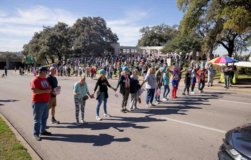 People block the road as the JFK Historical Group organizes a moment of silence at 12:30 pm...