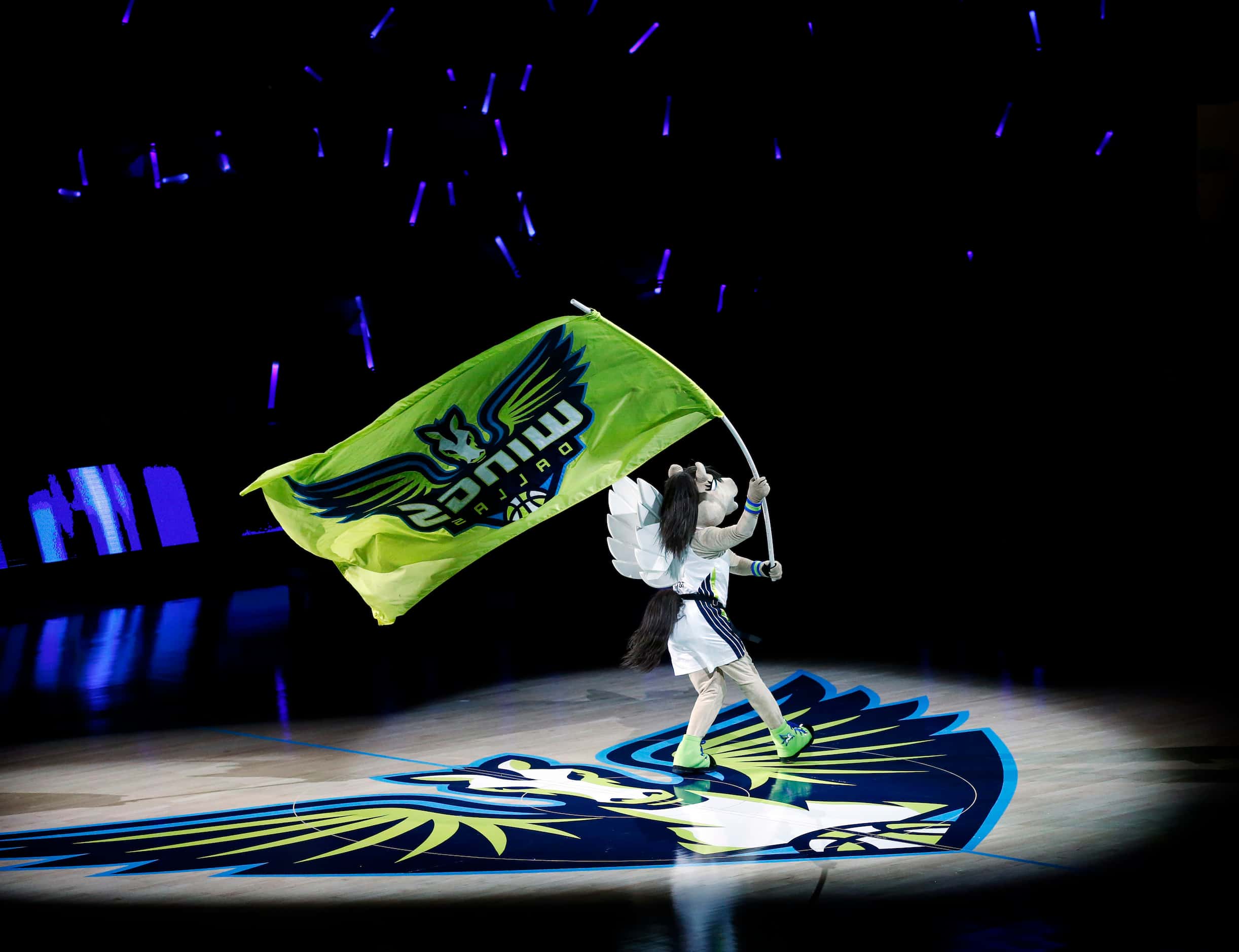 The Dallas Wings mascot Lightning waves the team colors during player introductions before...