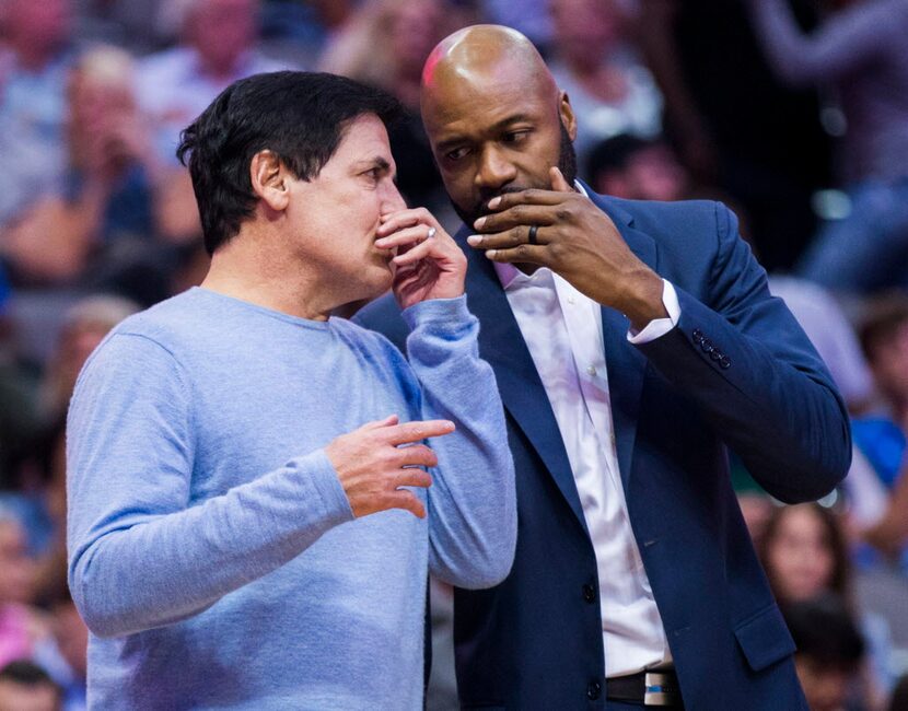 Dallas Mavericks owner Mark Cuban, left, discusses a play with  assistant coach Jamahl...