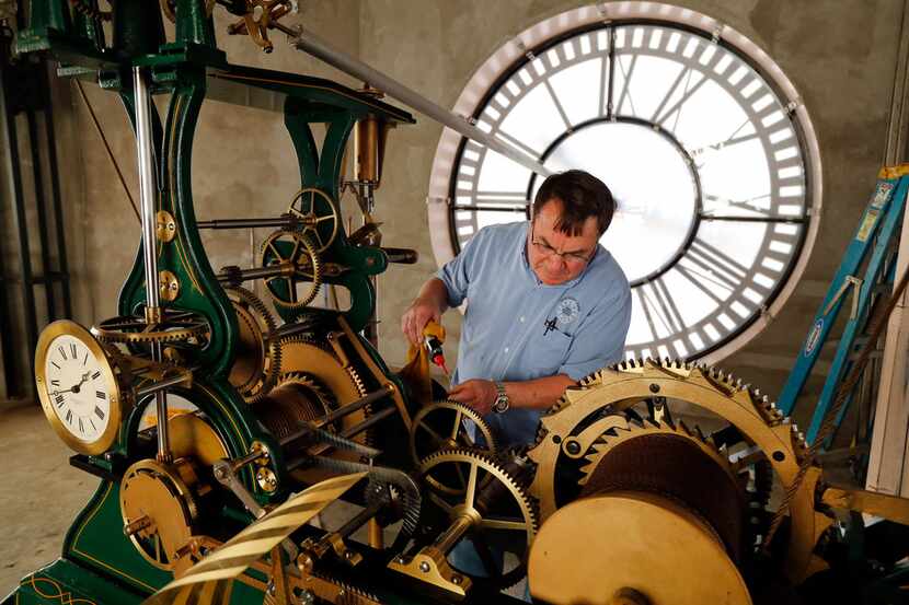 Historic clock restoration specialist Chuck Roeser Right) of Lockport, New York lubricates...