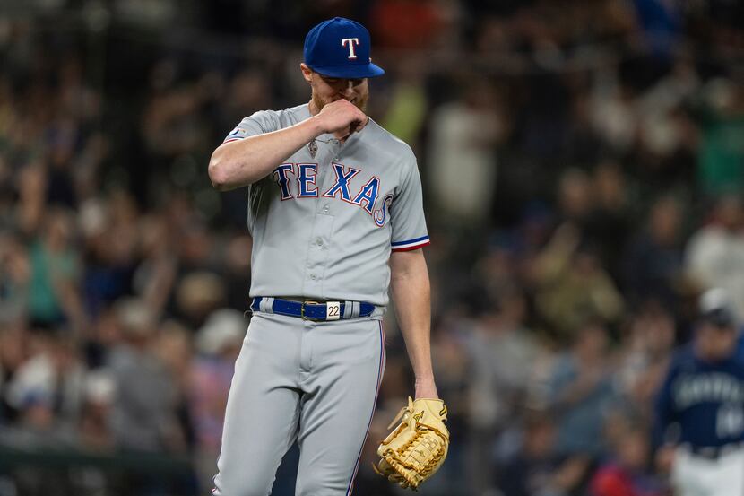 Texas Rangers starting pitcher Jon Gray reacts after giving up a home run to Seattle...