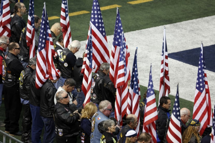 People bow their heads during a prayer during the memorial service for former Navy SEAL...