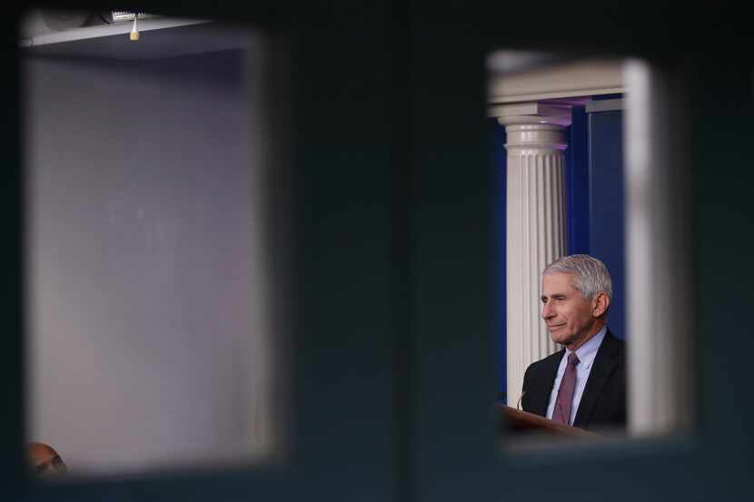 As seen through a door window, Dr. Anthony Fauci, director of the National Institute of...