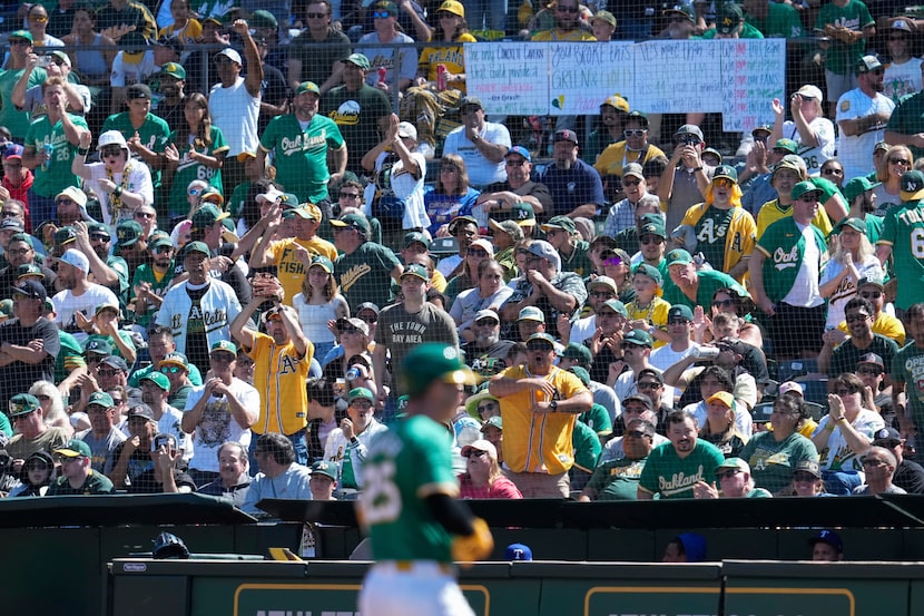 Oakland Athletics fans cheer after Brent Rooker (foreground) hit a single during the third...