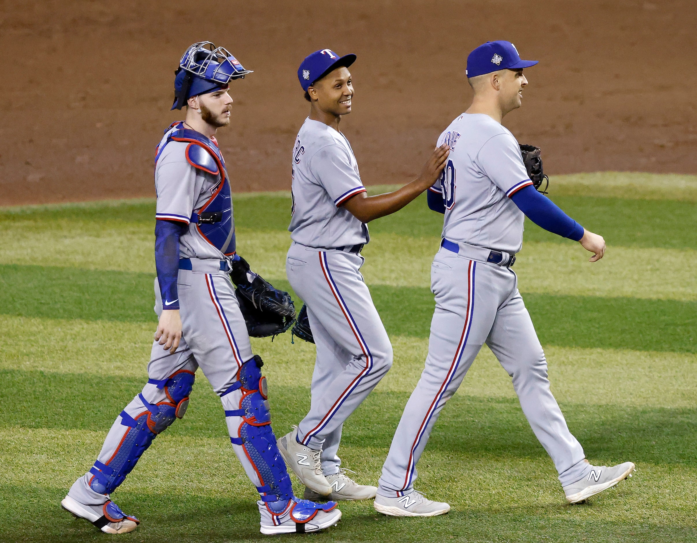 Texas Rangers relief pitcher Jose Leclerc (center) slaps first baseman Nathaniel Lowe (30)...