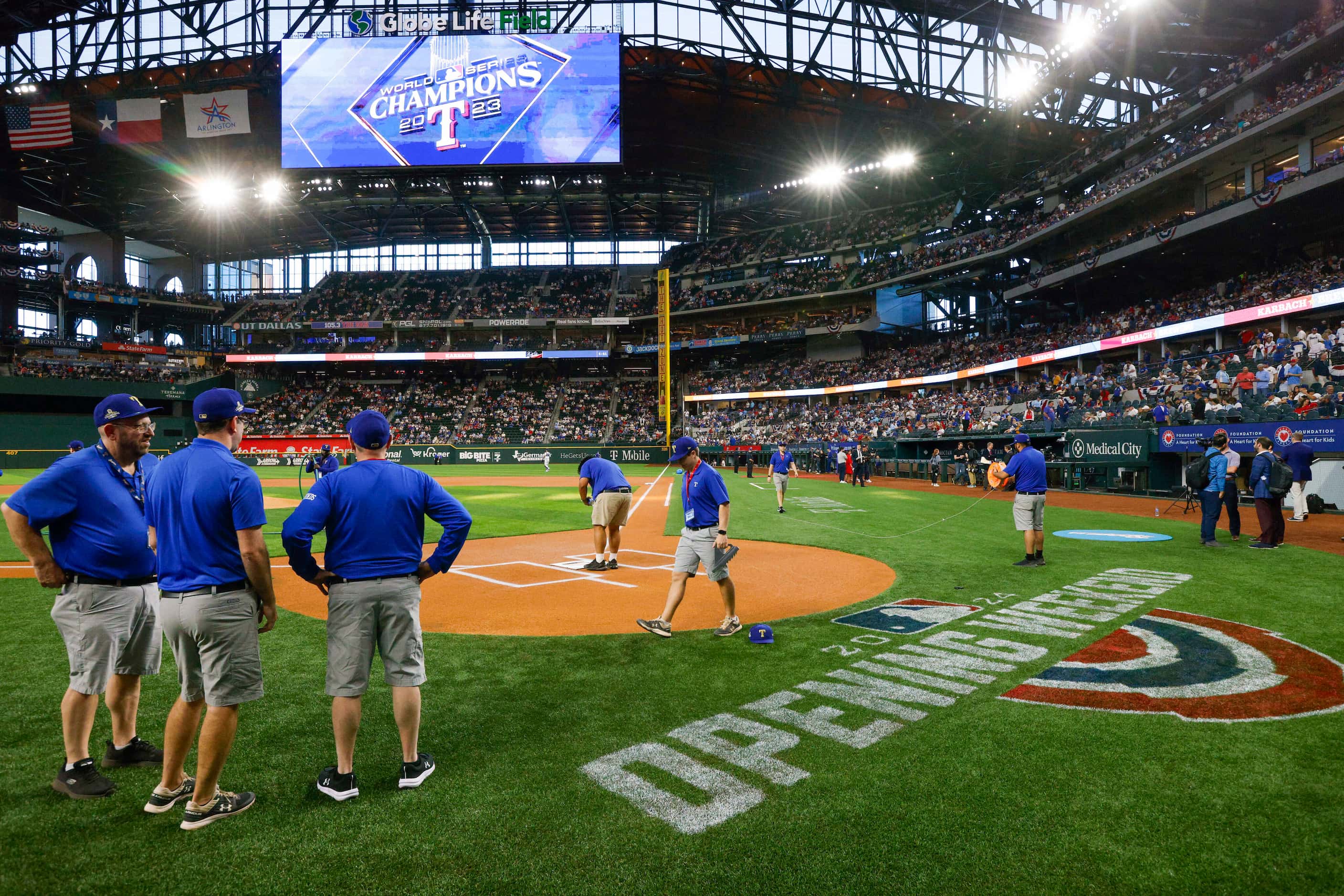 Texas Rangers groundskeepers paint the field before the season opener against the Chicago...