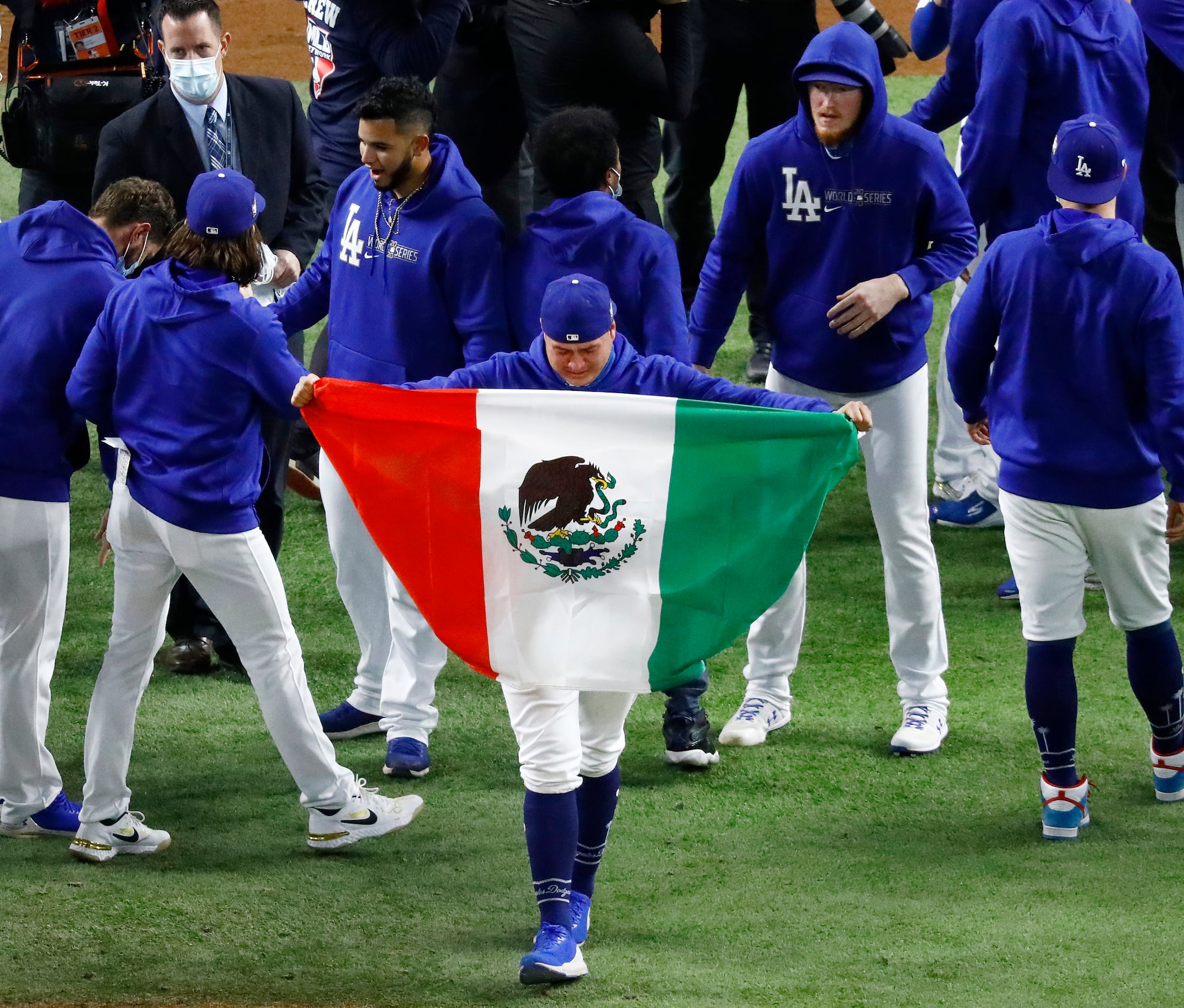 Los Angeles Dodgers starting pitcher Victor Gonzalez (with Mexican flag) is overcome with...