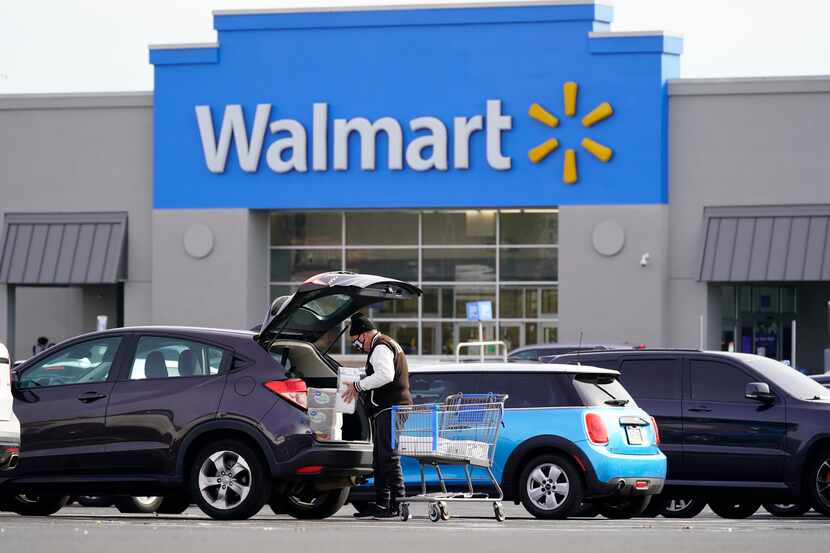 A customer loads a car after shopping at a Walmart in Philadelphia, Nov. 17, 2021.