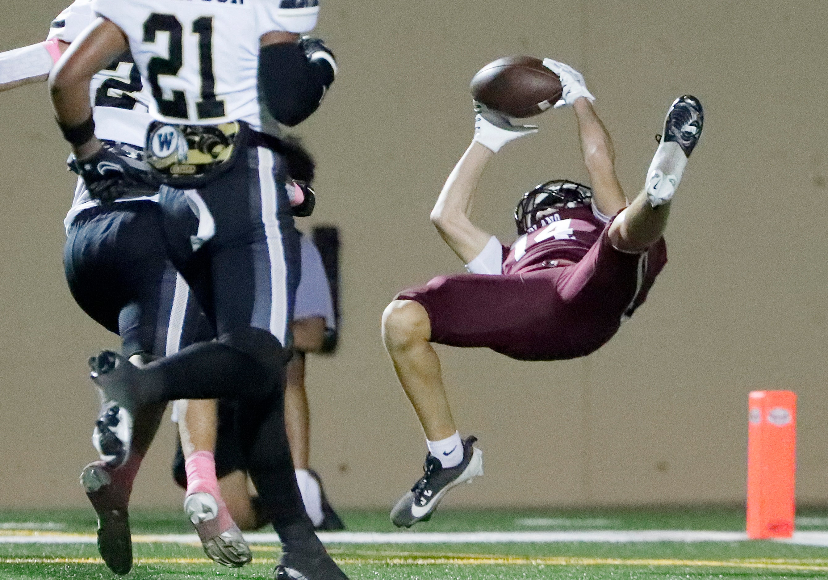 Plano High School wide receiver Thatcher Killion (14) makes a leaping catch for a touchdown...