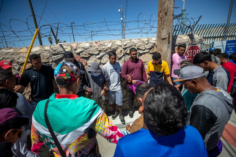In this photo taken on May 9, 2023, migrants pray before turning themselves in to...