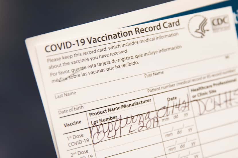 Gladys Rodgers, 77, holds her COVID-19 vaccination card at Fair Park in Dallas on Jan. 14,...