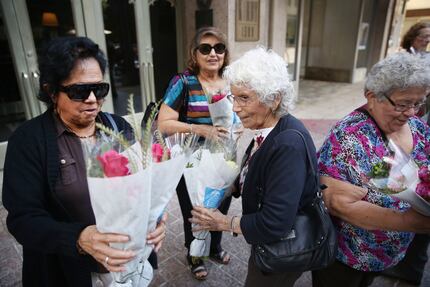 Angie Chapa (left), of Dallas, receives a bouquet of flowers while employees of Dr...