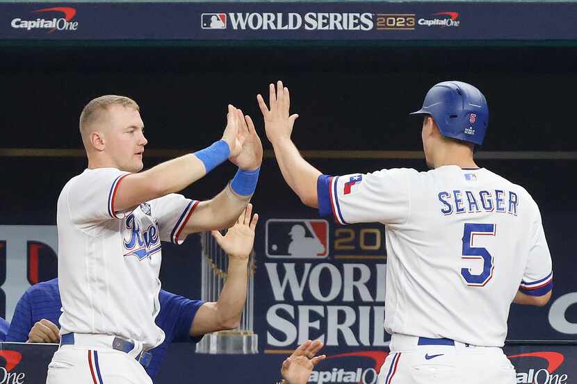 Texas Rangers' Corey Seager (5), right, celebrates with Josh Jung after scoring on a double...
