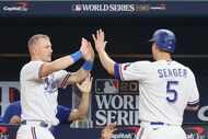 Texas Rangers' Corey Seager (5), right, celebrates with Josh Jung after scoring on a double...