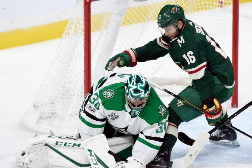 Dallas Stars goalie Ben Bishop (30) covers up the puck against Minnesota Wild left wing...