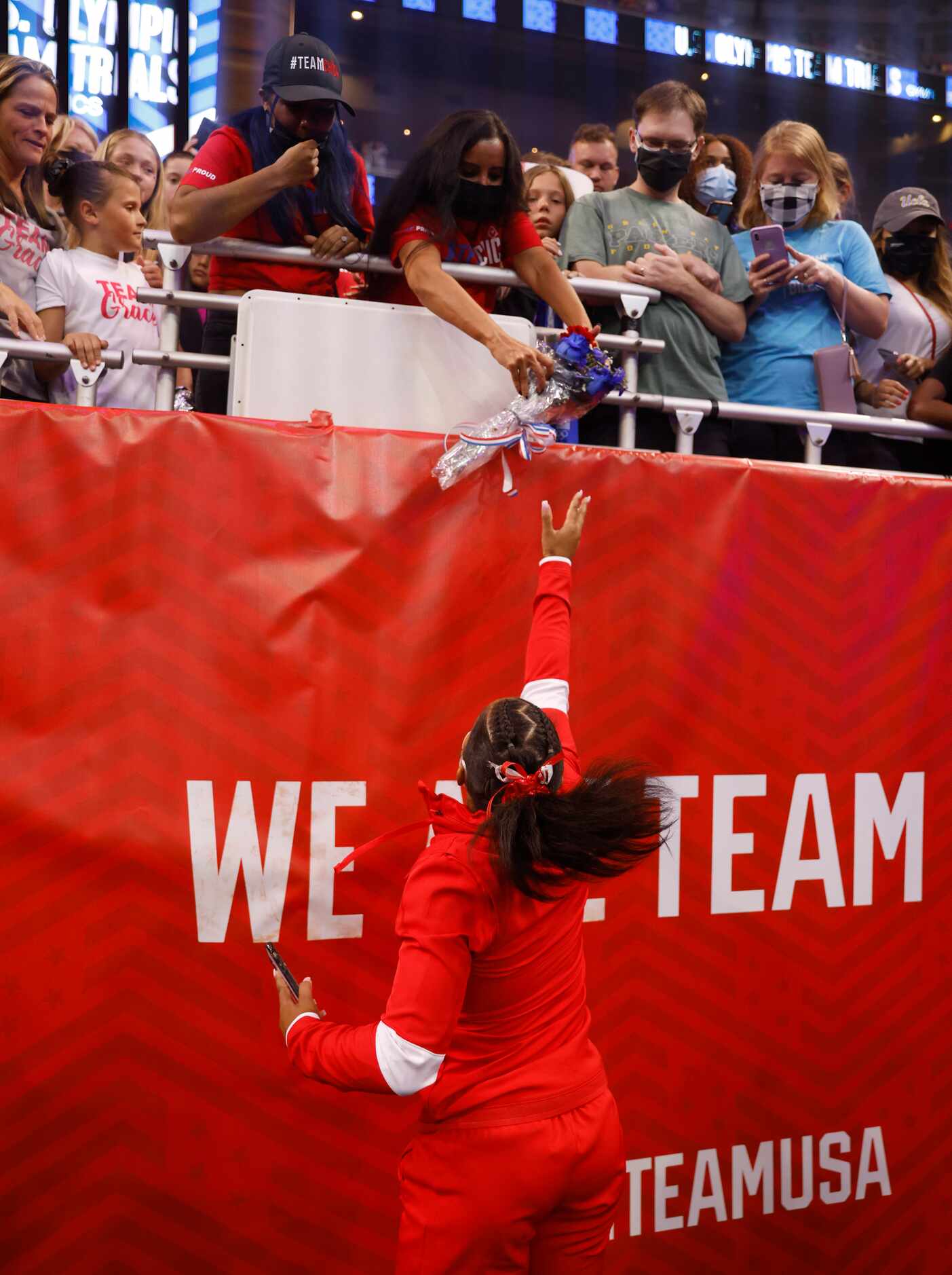 Jordan Chiles tosses flowers to her family after team announcements on day 2 of the women's...