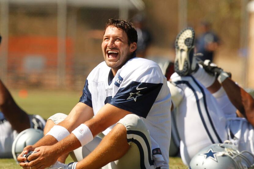 Dallas Cowboys quarterback Tony Romo (9) laughs while stretching during their afternoon...