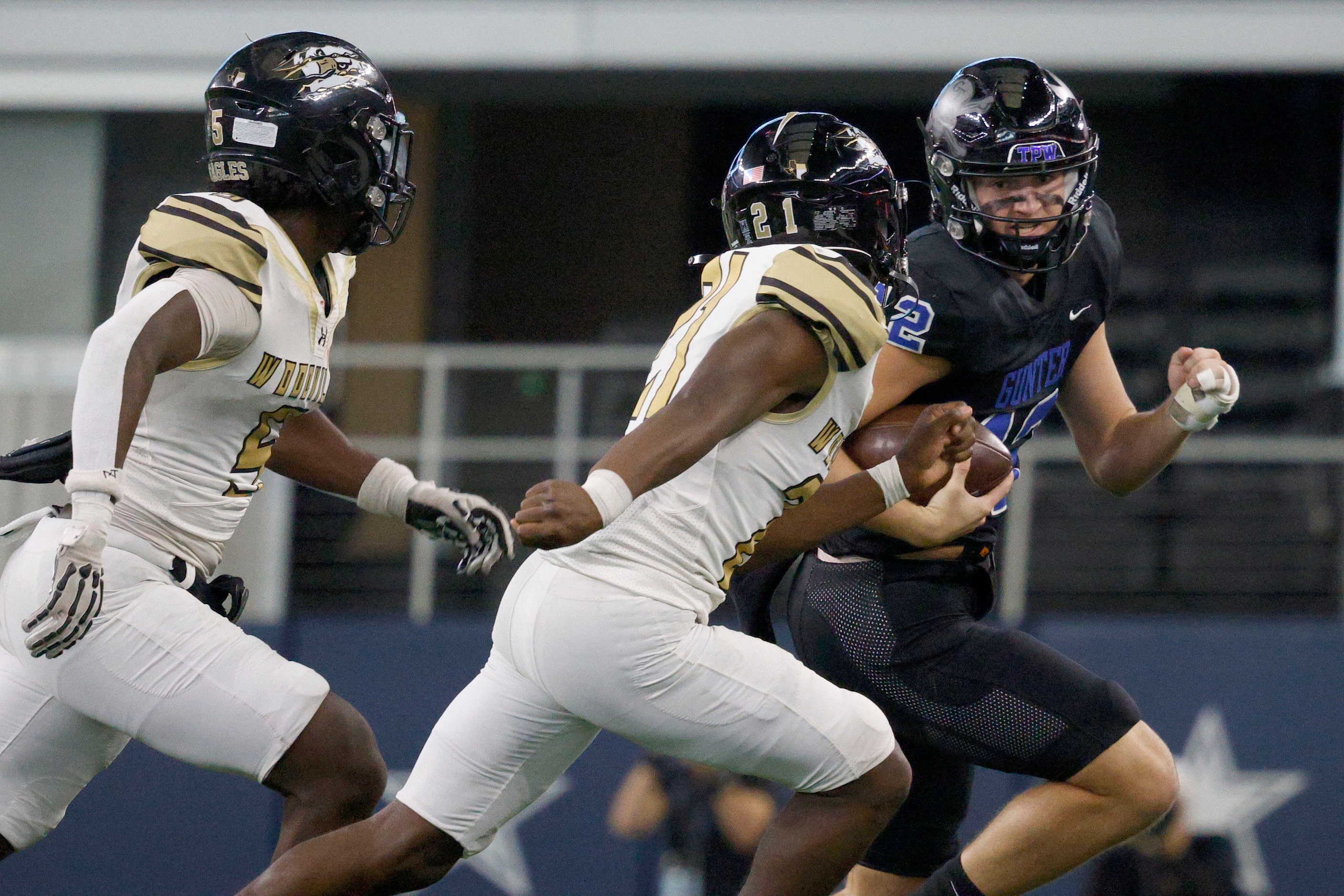 Gunter's  Preston Tarpley (12) keeps the ball away from Woodville's Jacob Hyder (5) and...