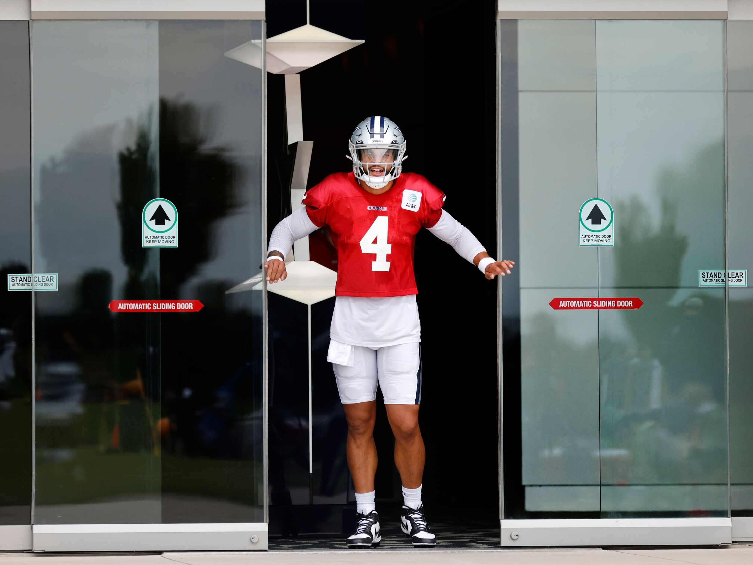 In a hurry to get to the field, Dallas Cowboys quarterback Dak Prescott pries open the doors...