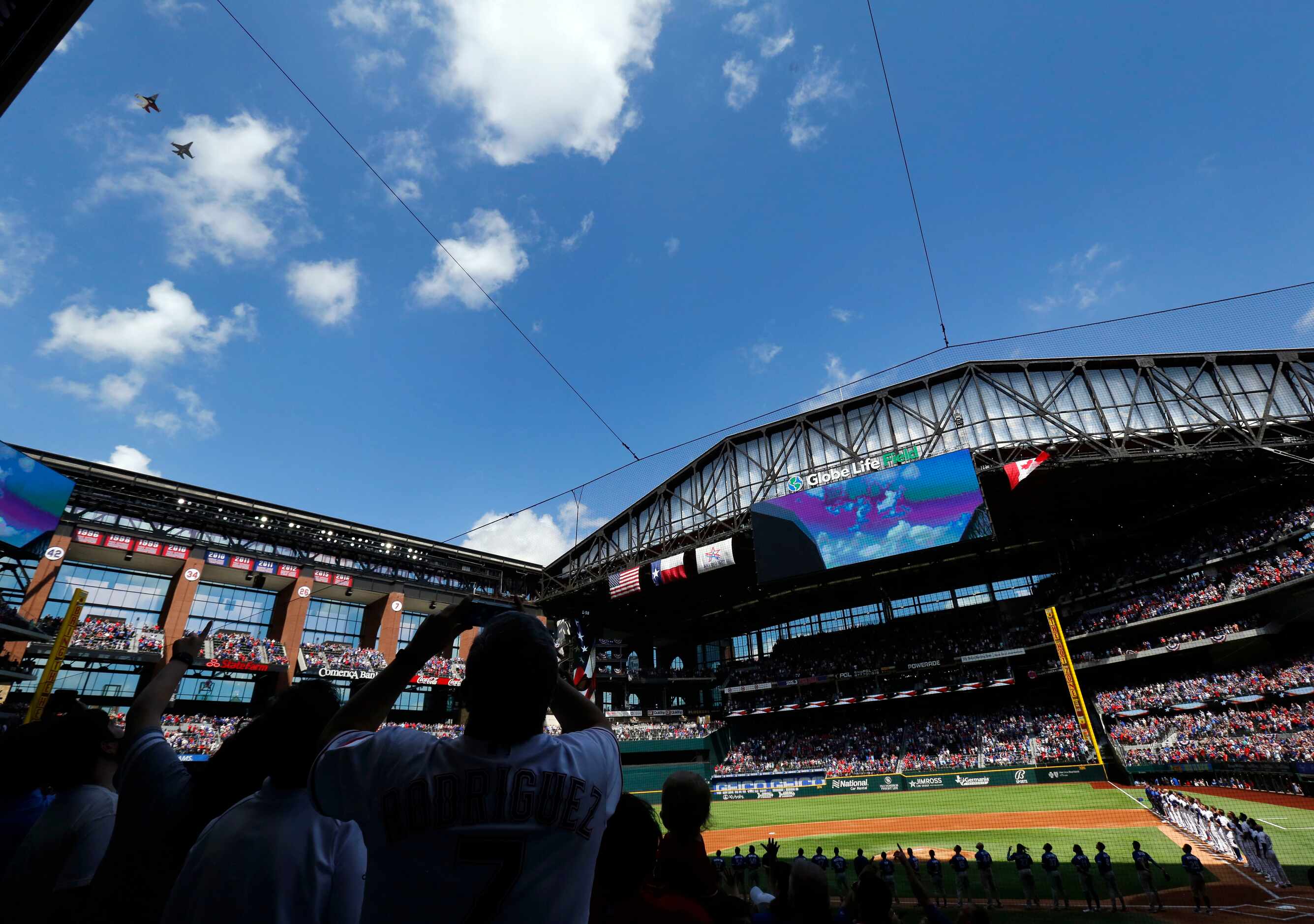 A pair of F-16 fighter jets flows over the the nearly sold-out Texas Rangers crowd following...