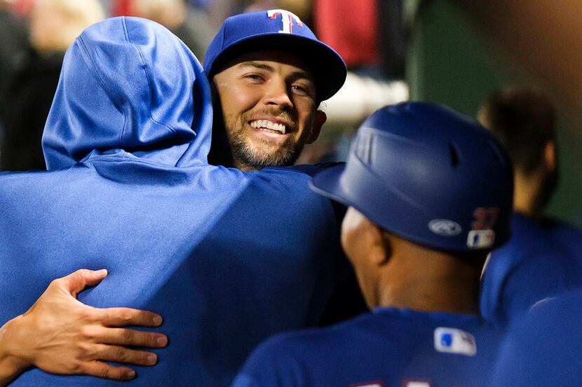 Texas Rangers pitcher Mike Minor gets a hug from pitcher Lance Lynn as he comes into the...