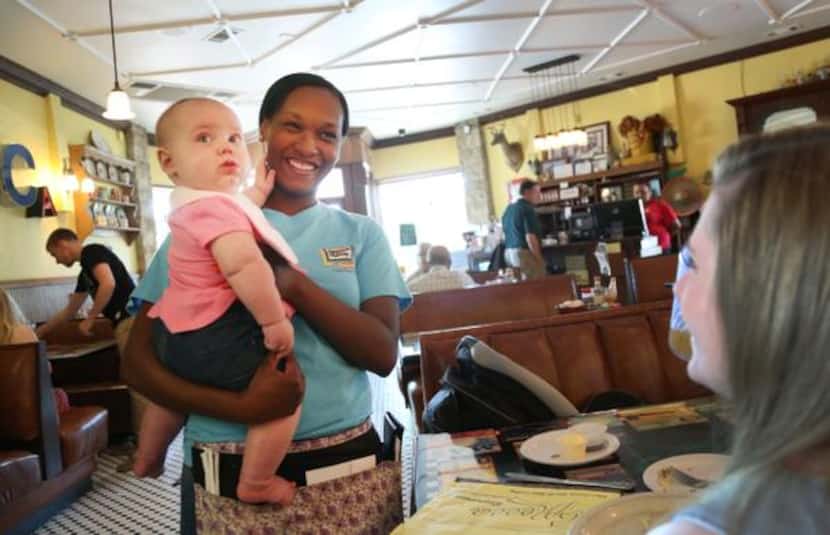 
Server Chloe Smith talks with Sarah Hammond as she holds her baby, 6-month-old Harper...