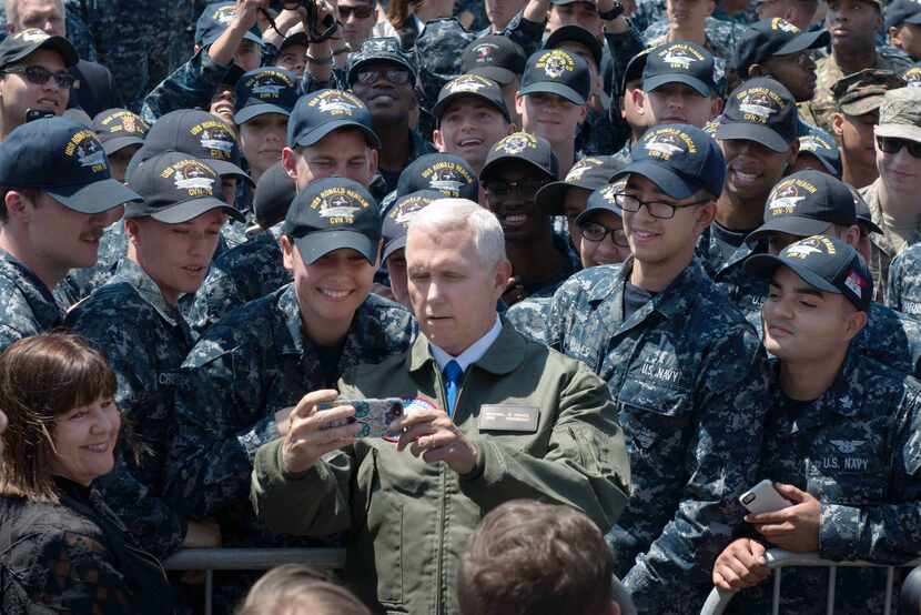 This US Navy handout photo shows US Vice President Michael R. Pence as he poses for a selfie...