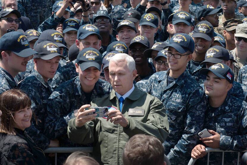 This US Navy handout photo shows US Vice President Michael R. Pence as he poses for a selfie...