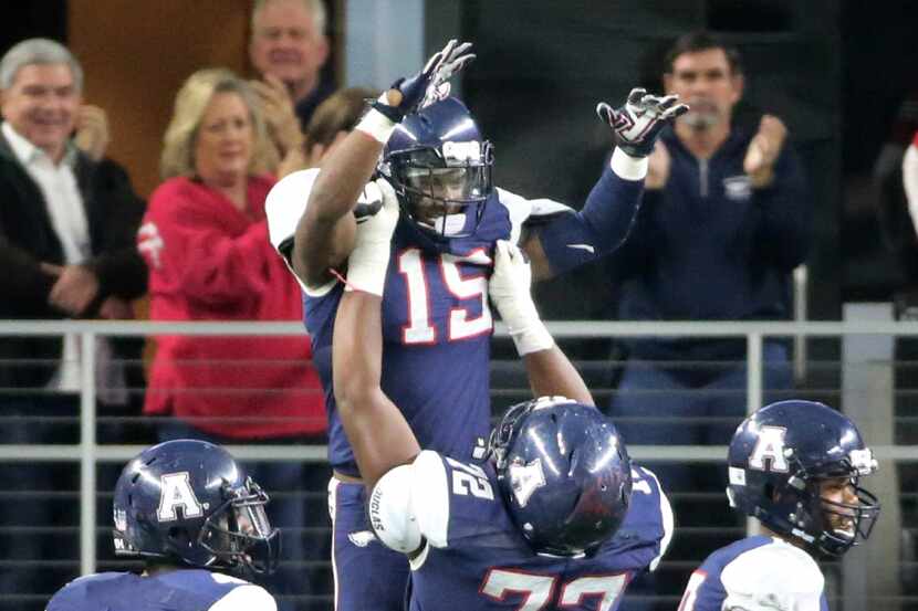 Allen running back Brock Sturges (15) is hoisted high by offensive lineman Will Sherman (72)...