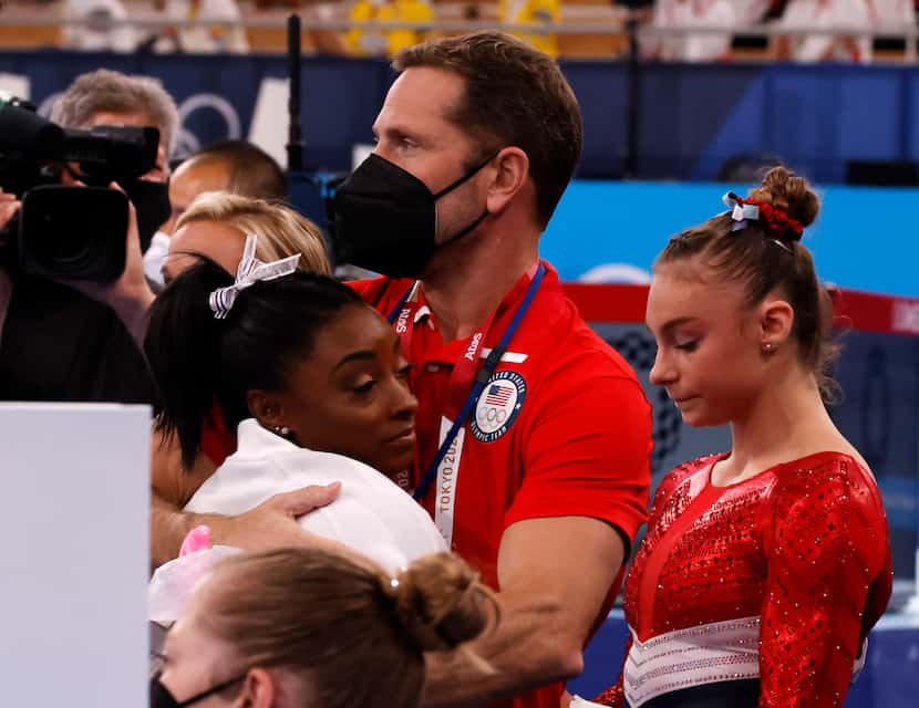 USA’s Simone Biles hugs coach Laurent Landi after returning to the field of play shortly...