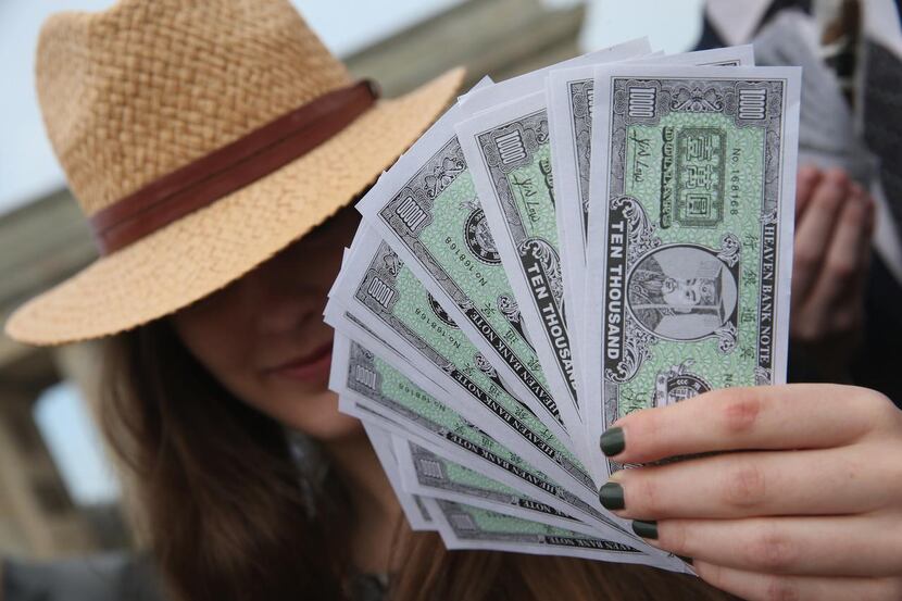 
An activist wearing a Panama hat holds fake money while demanding greater trasparency in...