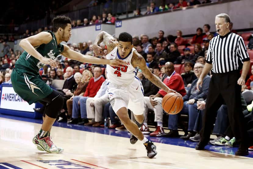 SMU guard Keith Frazier (4) looks for room against South Florida guard Troy Holston Jr. (25)...