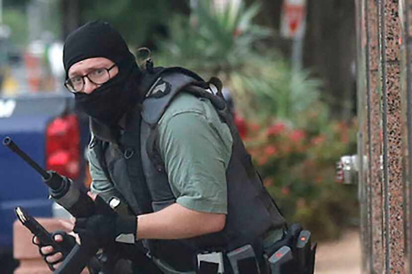 A masked gunman, later identified as 22-year-old Brian Isaak Clyde, makes his way along...