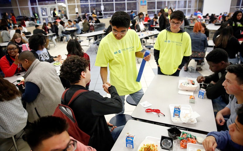 Duncanville High School freshman David Mojica (center) shakes hands with senior Paul Zamora...