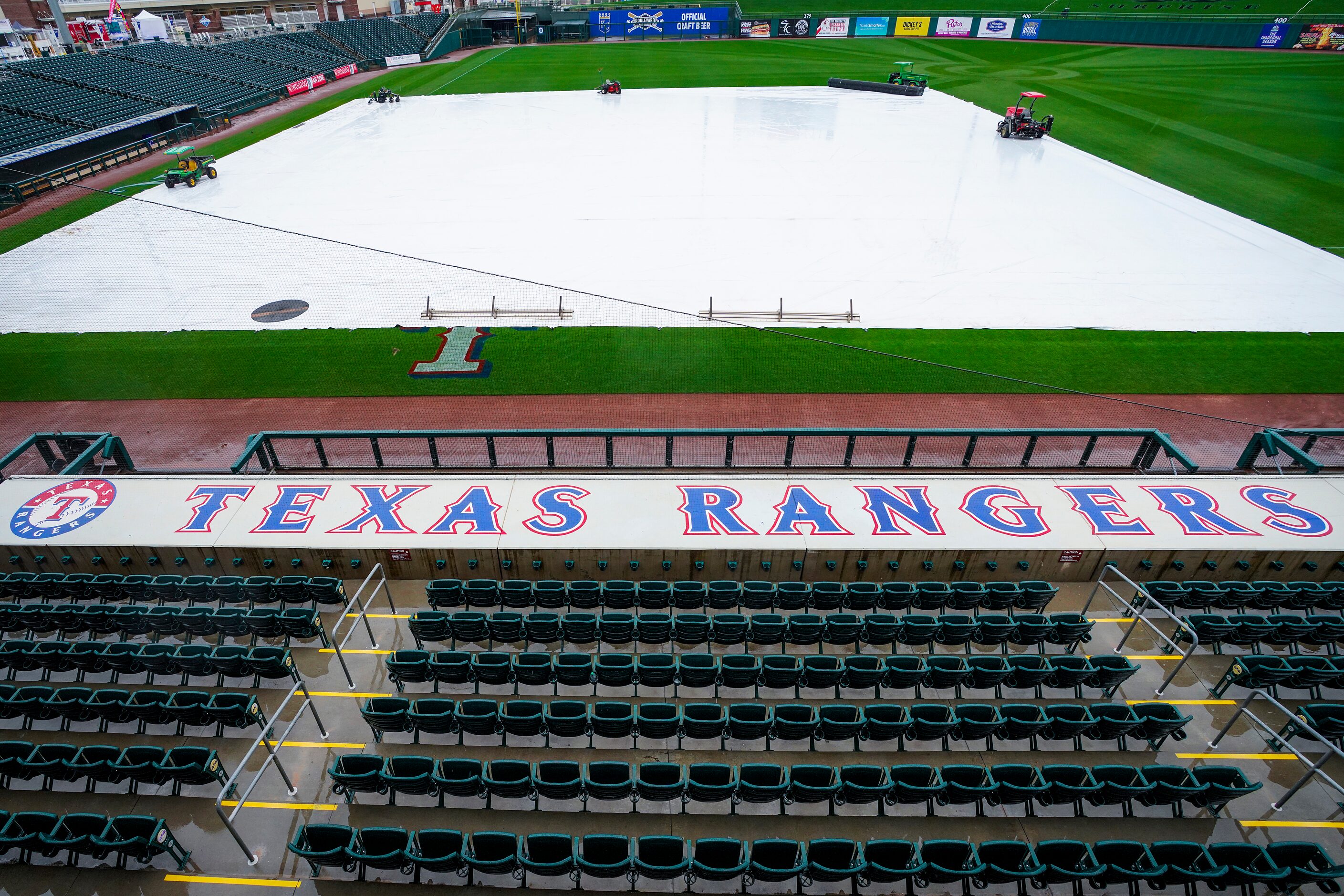 A tarp covers the field at Surprise Stadium as rain falls on Saturday, Feb. 22, 2020, in...