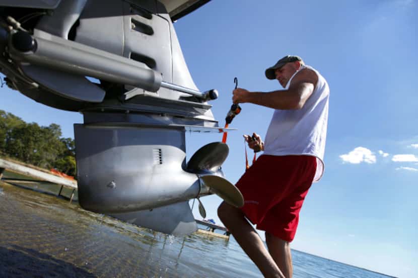 Brad Curtis of Denton secures his boat after pulling it from Lake Ray Roberts, where zebra...