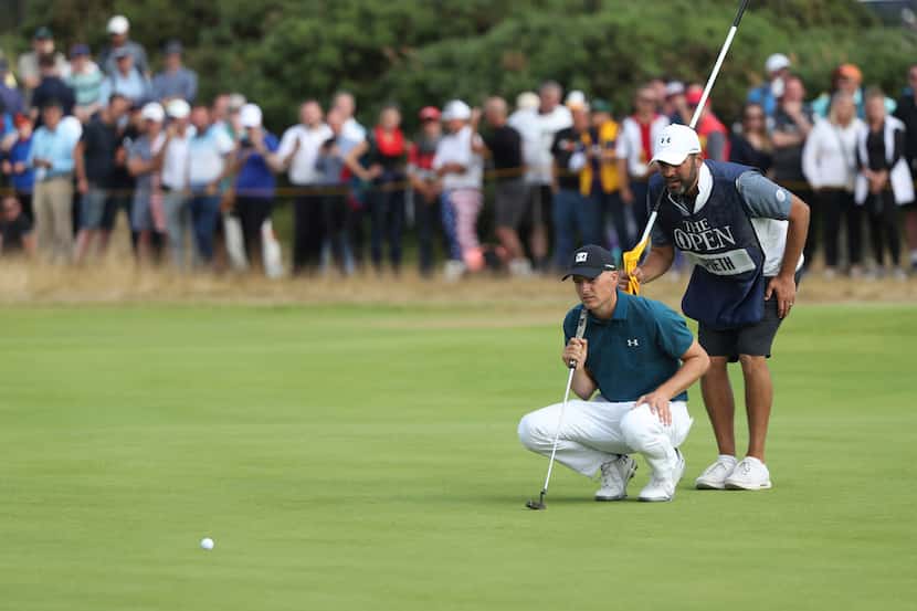 Jordan Spieth of the US and his caddie Michale Greller line up a putt on the 9th hole during...