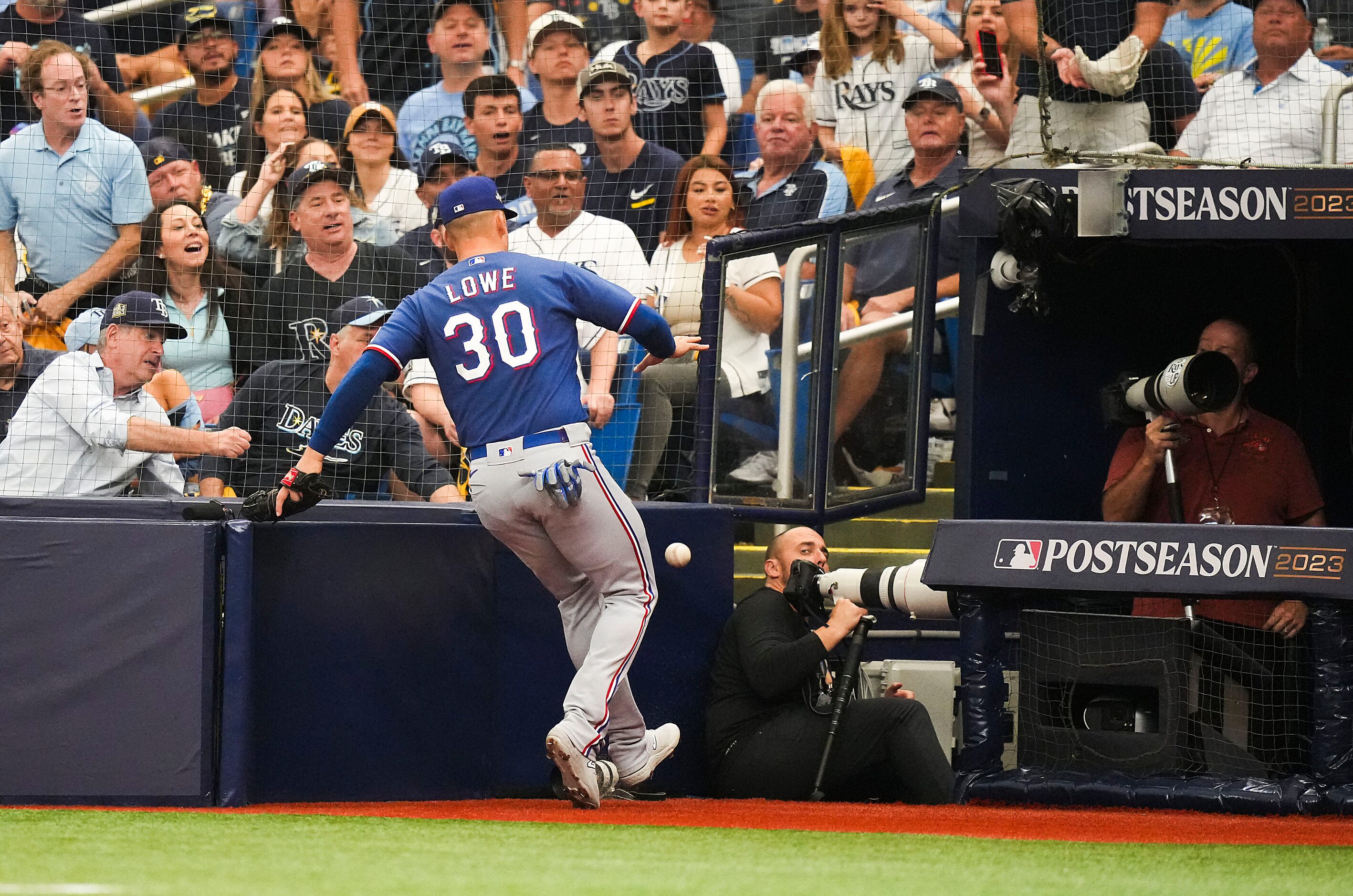 Texas Rangers first baseman Nathaniel Lowe (30) can’t make the play on a foul ball near the...