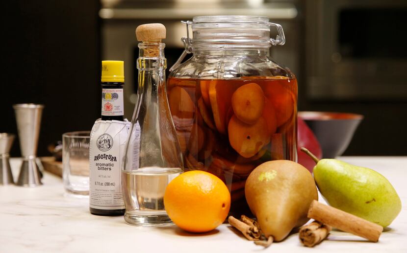 Bitters, simple syrup, orange and bourbon infused with cinnamon and pears for use in a...