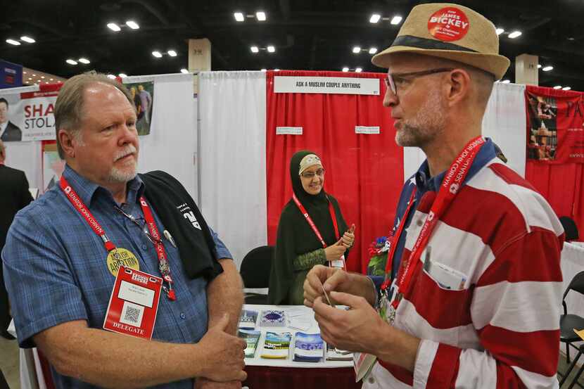 Clay Smith, right, talks with Brad Lewis as Smith mans the "Ask a Muslim Anything" booth at...