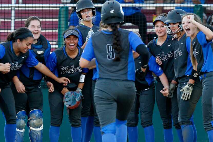 The Plano West team gathers around home plate to greet shortstop Sophia Mapes (9) after she...
