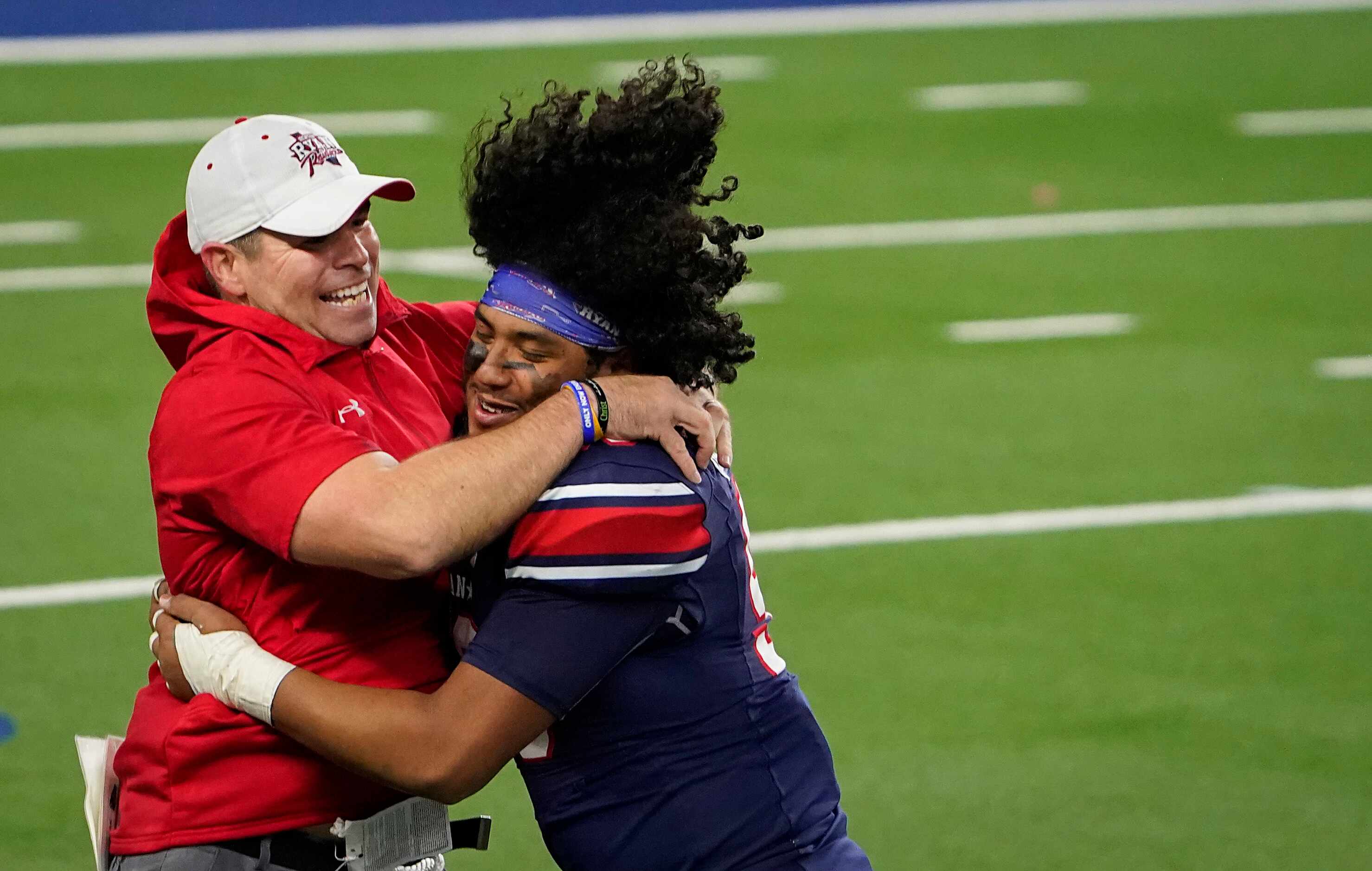 Denton Ryan offensive lineman Bryan Aguilar (56) hugs assistant coach Shane Tolleson as they...