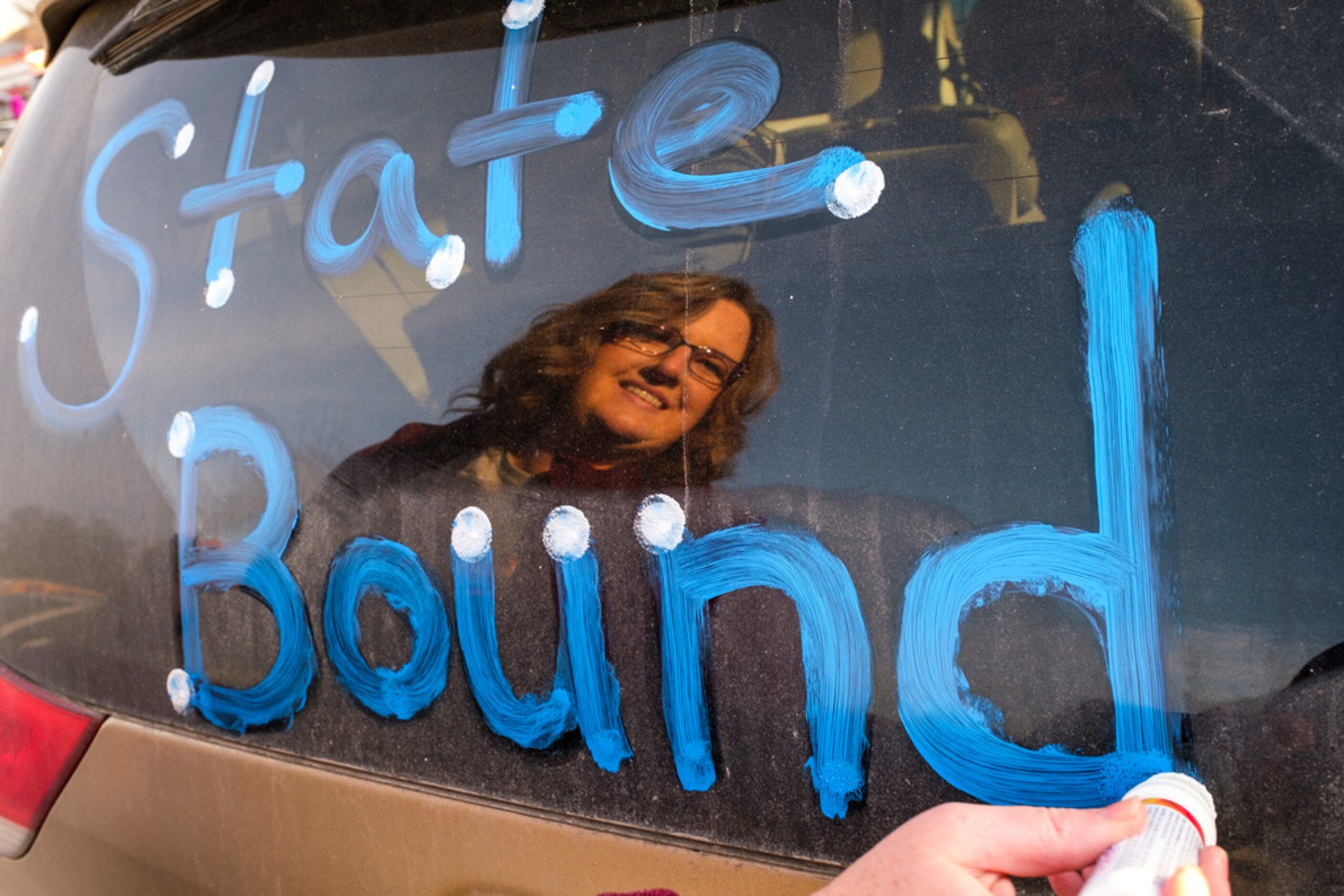 Kindergarten teacher Carrie Ricketts decorates her car in the parking lot before a send off...