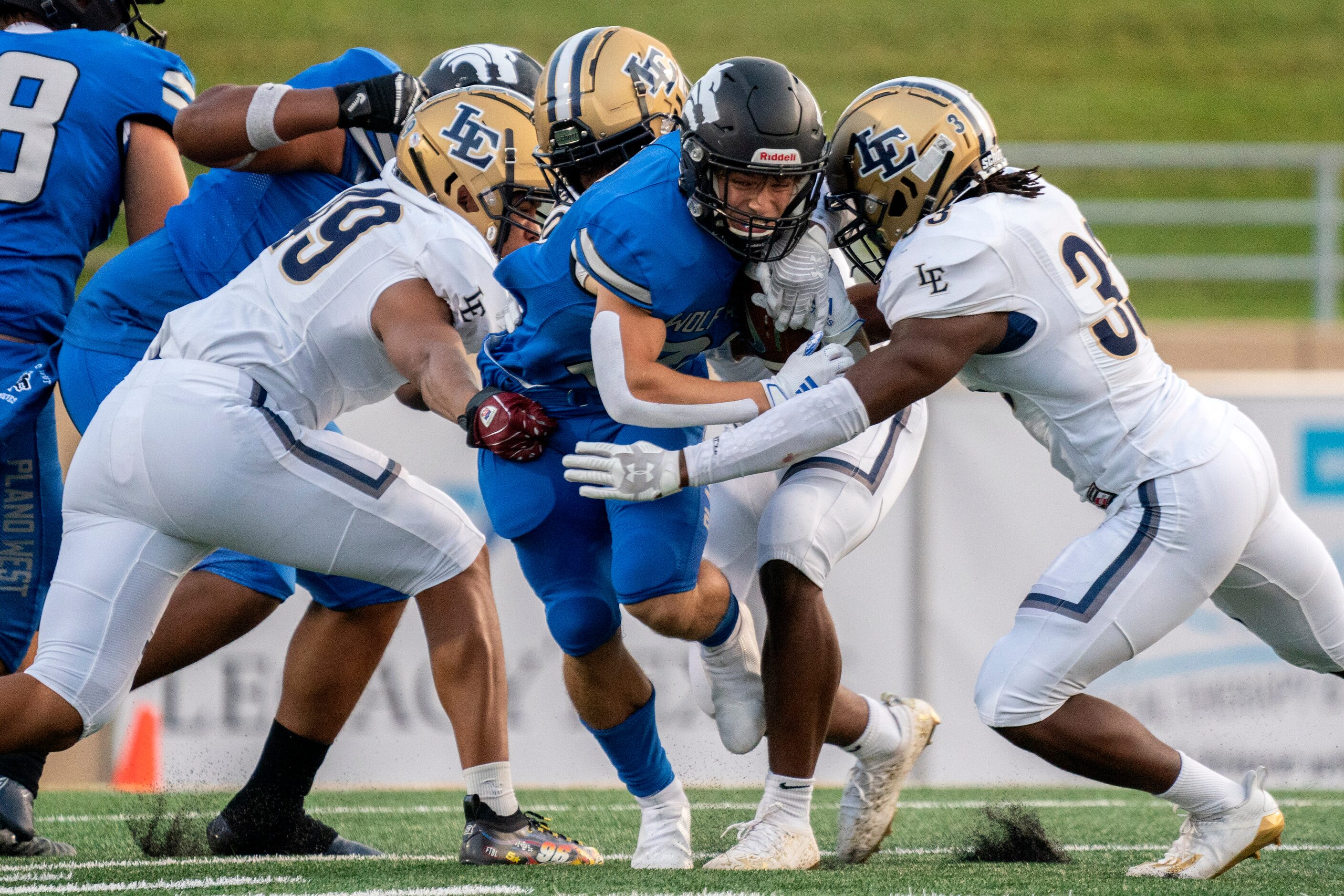 Plano West junior running back Dermot White (21) tries to break through the arms of Little...