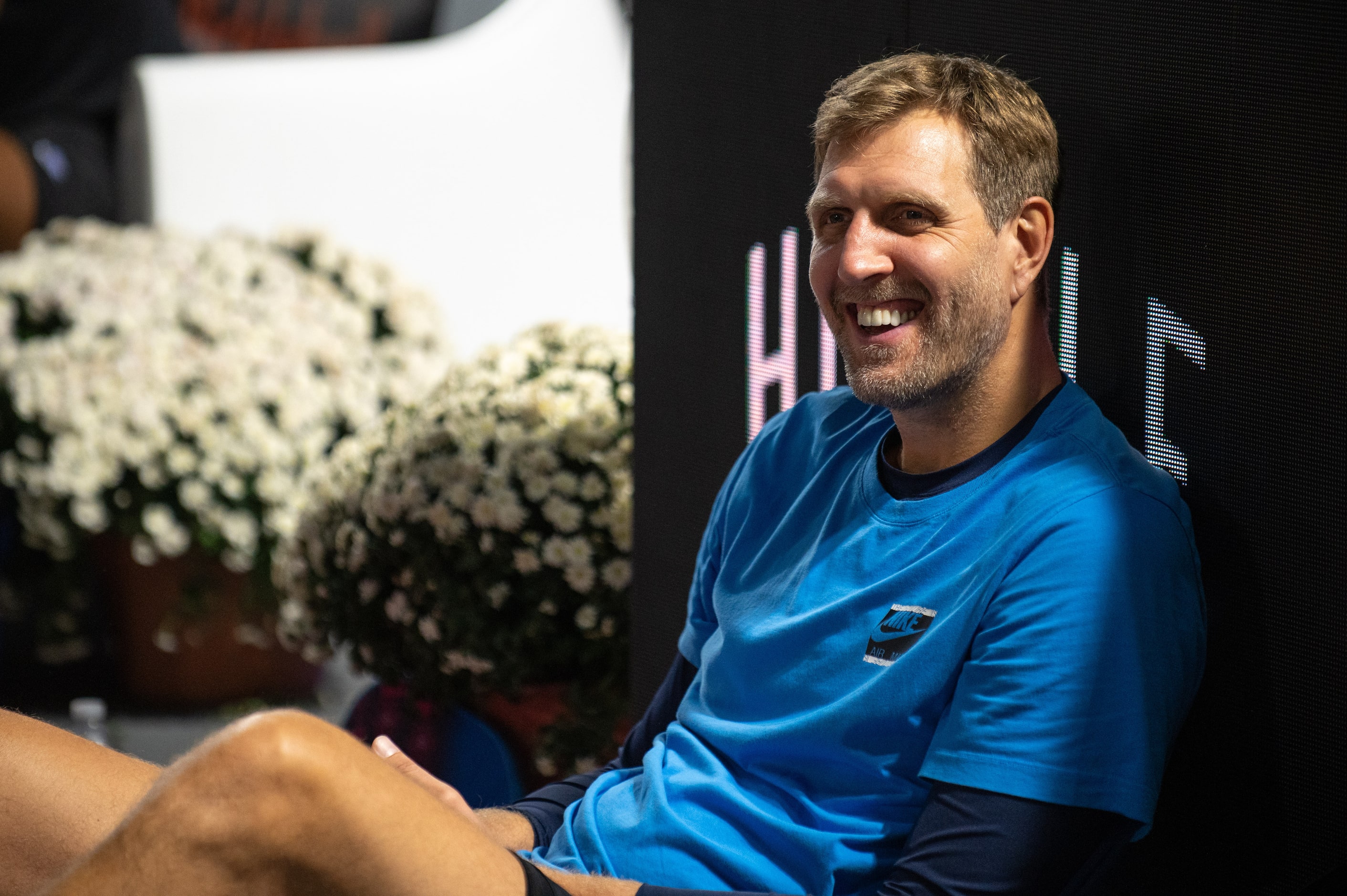 Former Dallas Mavericks center Dirk Nowitzki reacts with a smile while watching a fan play...