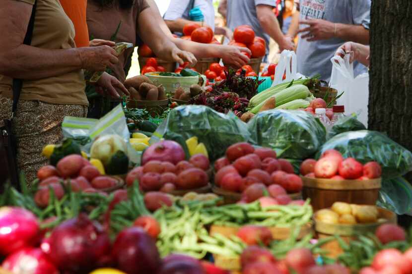 Marketgoers browse the vegetables at the McKinney Farmers Market. A study by lawn care...