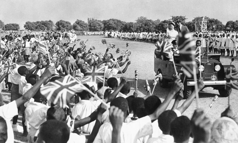 Thousands of flag-waving youngsters cheer as Queen Elizabeth II and the her husband Prince...